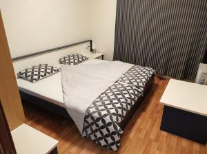 セインツ・コンスタンティン＆ヘレナにあるSea Point Apartmentsの小さなベッドルーム(ベッド1台、白黒の枕付)