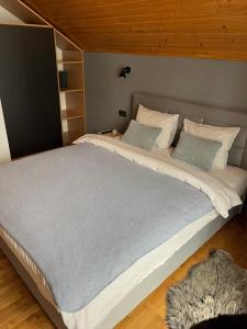 Cette chambre comprend un grand lit et un plafond en bois. dans l'établissement Chalet Mint, à Delnice