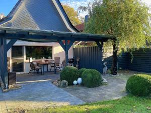 a patio with a blue pergola with a table and chairs at Ferienwohnung Greier in Neuenkirchen
