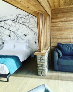 - une chambre avec un lit et une chaise dans l'établissement Appart Hôtel Le JAS, à Ancelle