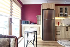 a kitchen with a stainless steel refrigerator and a stool at Charming Flat near Kennedy Avenue in Fatih in Istanbul
