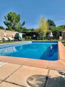 una piscina con acqua blu in un cortile di LA BASTIDE DES COCCINELLES a Villecroze