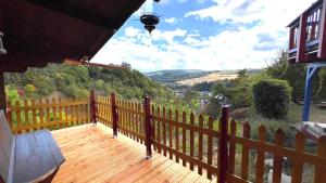 eine Holzterrasse mit einer Bank und einem Zaun in der Unterkunft Wie im Himmel in Hatzfeld
