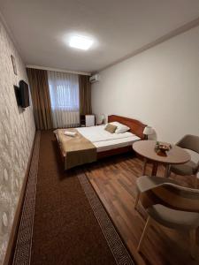 Schlafzimmer mit einem Bett, einem Tisch und Stühlen in der Unterkunft HOTEL New Milenium in Lukavac