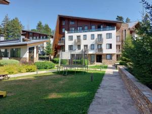 a building with a basketball hoop in front of a yard at Residence E205 Euphoria Borovets in Borovets