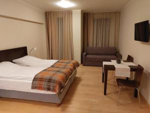 una camera da letto con un letto, un tavolo e un divano di Residence E205 Euphoria Borovets a Borovets
