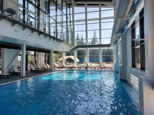 a large swimming pool with chairs in a building at Residence E205 Euphoria Borovets in Borovets