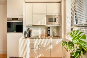 a kitchen with white cabinets and a counter at Cosy unit in Haywards Heath