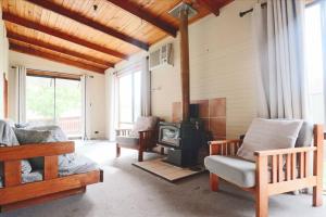 a living room with a wood stove and chairs at The Early Settler 200 metres from CBD in Bathurst