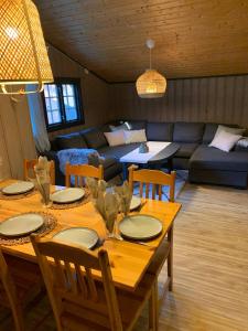 a living room with a wooden table with chairs and a couch at Enok Hytter & Resort in Liagardane