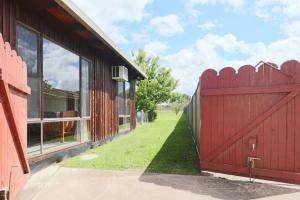 a red gate on the side of a house with a yard at The Early Settler 200 metres from CBD in Bathurst