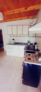 a kitchen with white cabinets and a stove top oven at Departamento en Trelew in Trelew