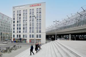 un grupo de personas caminando delante de un edificio en MEININGER Hotel Berlin Hauptbahnhof, en Berlín