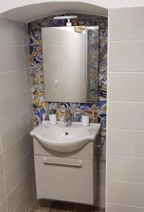 ein Badezimmer mit Waschbecken und Spiegel in der Unterkunft Seaside Sartoria in Bari