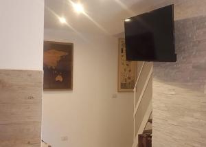 ein Flachbildfernseher, der an einer Wand hängt in der Unterkunft Seaside Sartoria in Bari + 8 Fotos