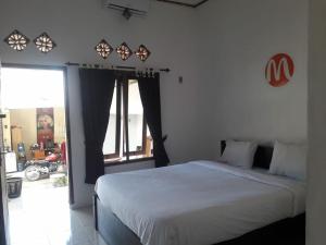 a bedroom with a bed and a large window at Mugeni Homestay in Senggigi 