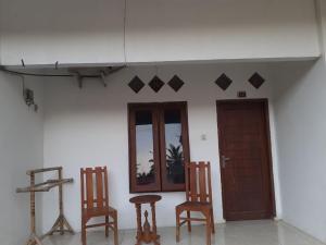 um quarto com cadeiras, uma mesa e uma porta em Mugeni Homestay em Senggigi