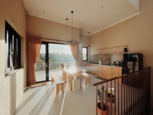 a kitchen and living room with a large window at XOM House Biển Hồ in Bien Ho
