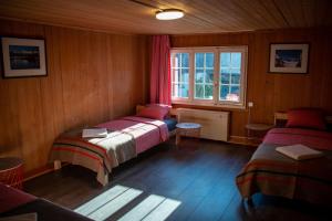 - une chambre avec 2 lits et une fenêtre dans l'établissement Uncle Eric's Chalet, à Matten