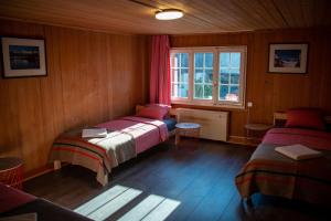 a bedroom with two beds and a window in it at Uncle Eric's Chalet in Matten