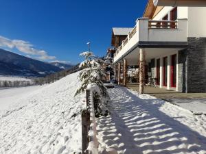 a snow covered building with a snow covered fence at Ferienwohnung Sunnseitn in Haus im Ennstal