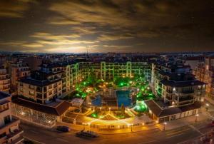 a large building with green lights in a city at night at Boutique Rose Gardens Pomorie in Pomorie