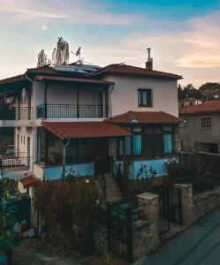 una gran casa blanca con una valla delante en Ξενώνας Ράπτης 