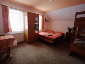 a small bedroom with a bed and a window at Apartmány 670 pod Lysou horou in Rokytnice nad Jizerou