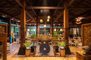 a large room with a table and potted plants at Abhayagiri - Sumberwatu Heritage Resort in Yogyakarta