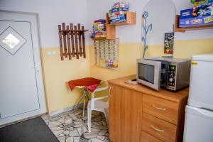 een keuken met een bureau, een magnetron en een televisie bij Pokoje Gościnne Justynka in Władysławowo