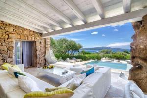 een woonkamer met een witte bank en een zwembad bij Luxury Villa in Porto Rotondo in Porto Rotondo