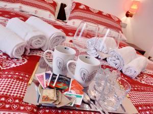 a red and white bed with cups and dishes on it at Cèsa Cherpei - Pet Friendly in Campitello di Fassa