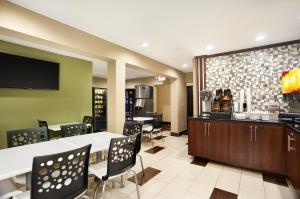 un restaurante con bar, mesas y sillas en Super 8 by Wyndham Joplin, en Joplin