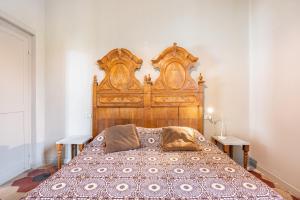 - un grand lit dans une chambre avec une tête de lit en bois dans l'établissement Colorno Apartment c/ Parcheggio vicino alla Reggia, à Colorno