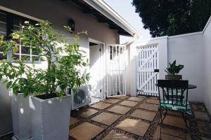 Un patio con plantas en macetas y una cerca blanca. en 25A Oyster, en Durban