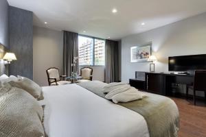 a hotel room with a bed and a desk and a computer at Iberik Santo Domingo Plaza Hotel in Oviedo