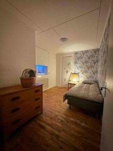 1 dormitorio con 1 cama, vestidor y tocador en Fantastisch familiehuis met sauna aan het water en Föllinge