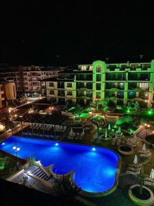 a large building with a swimming pool at night at Boutique Rose Gardens Pomorie in Pomorie