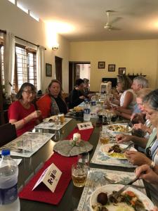 Eine Gruppe von Menschen, die an einem langen Tisch sitzen und Essen essen. in der Unterkunft Kuruvinakunnel Tharavadu in Kottayam