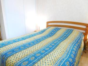 サルゾーにあるAppartement Polのベッド(青と黄色の毛布付)