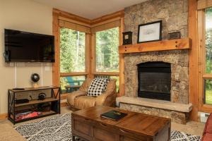 a living room with a stone fireplace and a couch at 6532 Settlers Creek Condo in Keystone