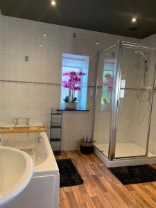 a bathroom with a shower and a sink and a tub at The Shires - Quirky 3 bed holiday home with Wood-fired Hot-tub in Rudston