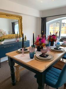 a dining room table with candles and vases on it at The Shires - Quirky 3 bed holiday home with Wood-fired Hot-tub in Rudston