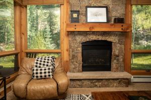 a living room with a fireplace and a leather chair at 6532 Settlers Creek Condo in Keystone
