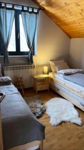 a bedroom with two beds and a window with rugs at Chalet Mint in Delnice