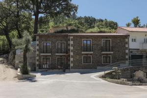 une maison en briques avec une allée en face de celle-ci dans l'établissement Casa da Fonte - Gerês, à Gerês