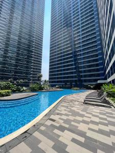 a swimming pool in a city with tall buildings at Homey 1 Bedroom Unit at Air Residences in Manila