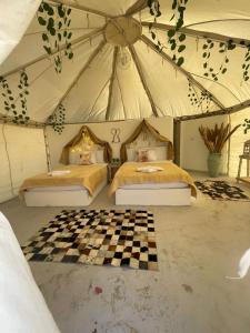 een slaapkamer met 2 bedden in een tent bij Shahrazad Camp in white desert, Egypt in Qasr Al Farafirah