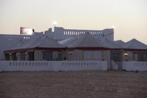 een wit gebouw met een rij daken bij Shahrazad Camp in white desert, Egypt in Qasr Al Farafirah