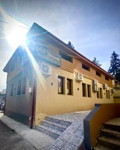 a building with the sun shining on the side of it at Clarina All Seasons Rooms & Apartments in Kruševo